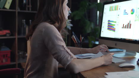 Young-woman-business-analyst-using-computer-to-generate-financial-report