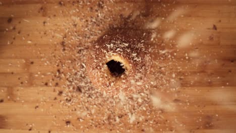 cinematic shot of chopped nuts being sprinkled on chimney cake pastry, top-down