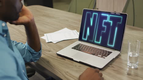 african american businessman using laptop for video call with nft text