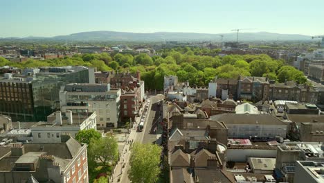 reversing aerial of dublin city centre and st stephen's green in dublin, county leinster, ireland. the luas passes underneath. filmed in 4k, 60fps and with rec709 color.