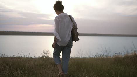 beautiful female art artist preparing her sketchbooks and easel to the work. lake and clear blue sky in the evening dusk. nature