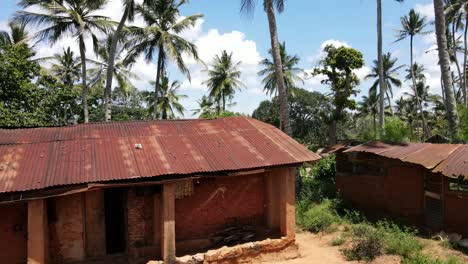 drone flies between the huts of a village in east africa on the kenyan coast