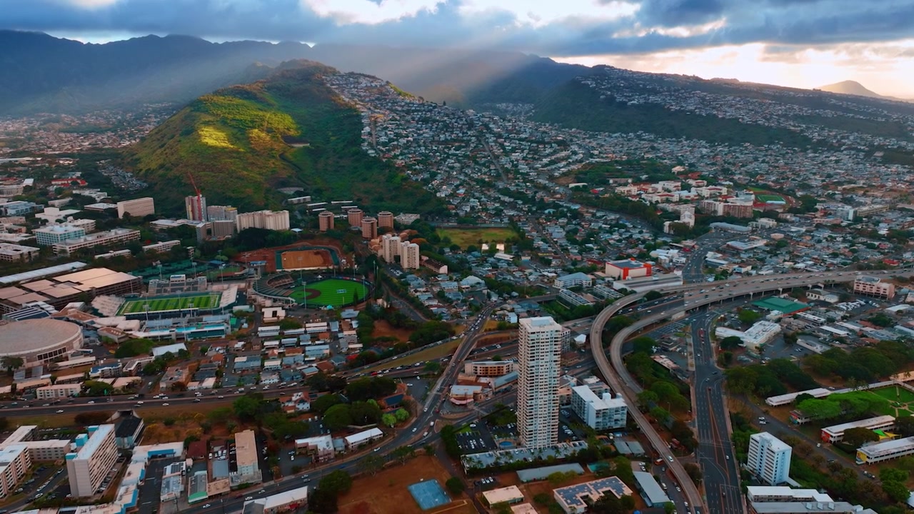 Traffico vivace sulle strade di Honolulu, Oahu, Hawaii, USA. Vasto paesaggio urbano su un terreno irregolare. Vista aerea
