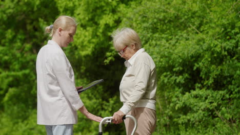 young woman assisting elderly woman in park