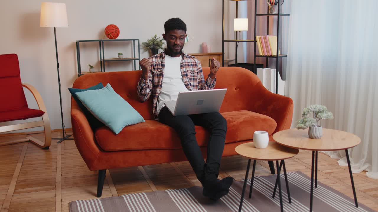 Young adult man at home office use laptop pc typing browsing say wow yes found out great big win