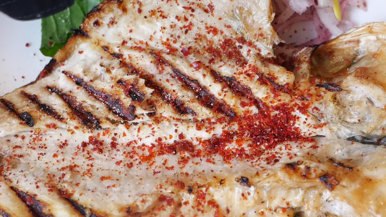 pescado a la parrilla con escamas de pimienta roja