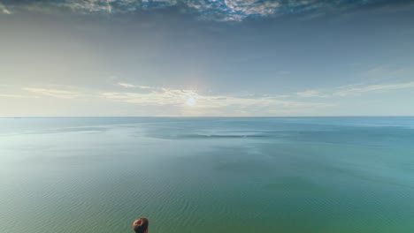 the traveler is standing on the mountain range on the seascape background