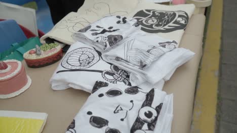 close-up of set of garments with design printed on fabric. artisans fair selling items. mexico.