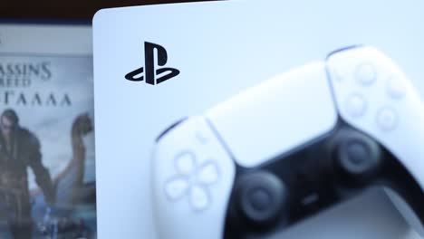 playstation 5 console and dualsense controller with assassin's creed game