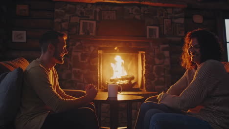 couple cozying up by a fireplace in a cabin