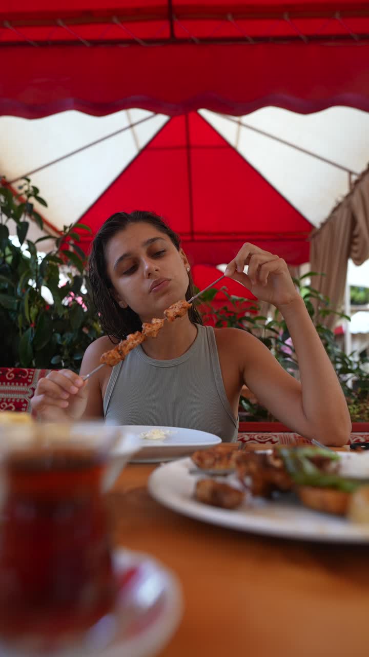 una mujer disfrutando de kebabs turcos.