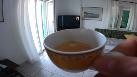 pov: a person walks around with a cup of coffee in hand to drink it outside on the terrace