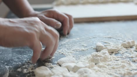 two hands making dough for meat dumplings.