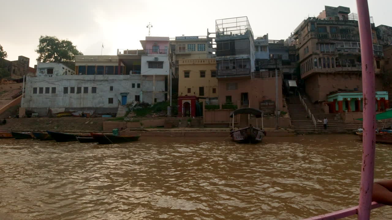 cinematográfico varanasi india ganges río canal crucero en barco estado del norte reunión antigua ciudad santa provincia de ghat pradesh paisaje gris nublado por la tarde fangoso marrón a la izquierda