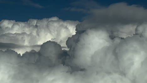 left side aerial view shot from a jet cockpit flying through a stormy sky full of storm clouds. 4k 60fps