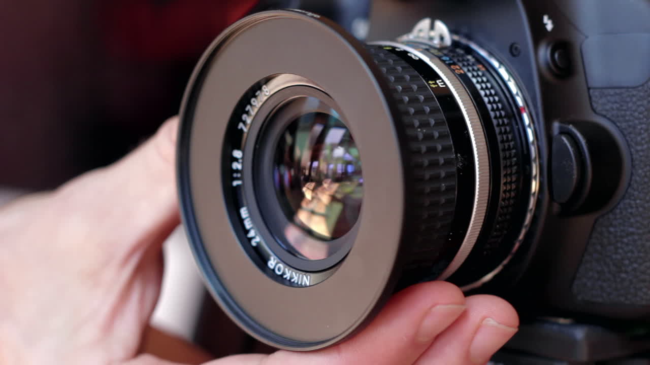 Mano masculina ajusta el anillo de enfoque manual en una lente DSLR