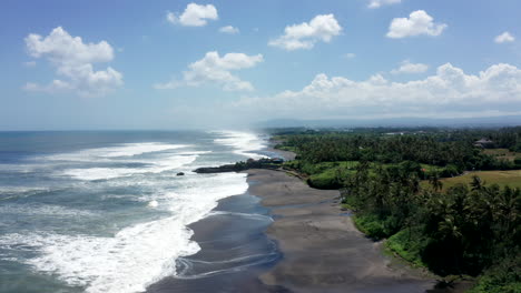 Aerial-drone-footage,-coastline-with-black-rocks-in-Bali