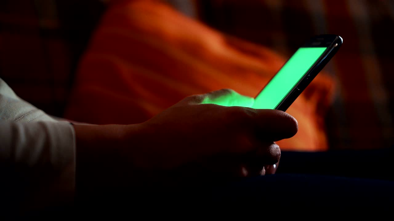 Donna che usa uno smartphone con schermo verde.