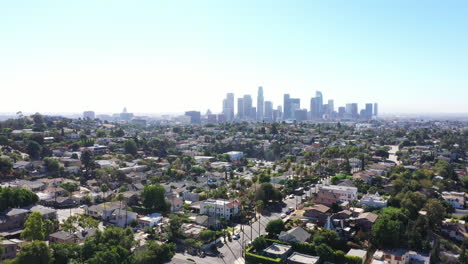 Beautiful-drone-shot-of-Los-Angeles,-California-showing-the-city,-palm-tree-lined-streets-and-houses