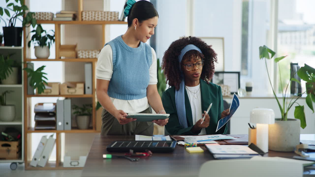 Two Diverse Businesswomen Collaborating on Project in Modern Office