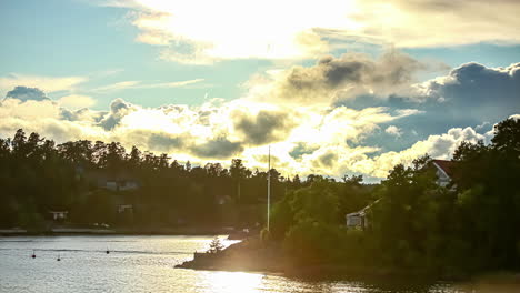 Timelapse-shot-of-dense-rain-cloud-movement-over-village-alongside-a-river-at-daytime