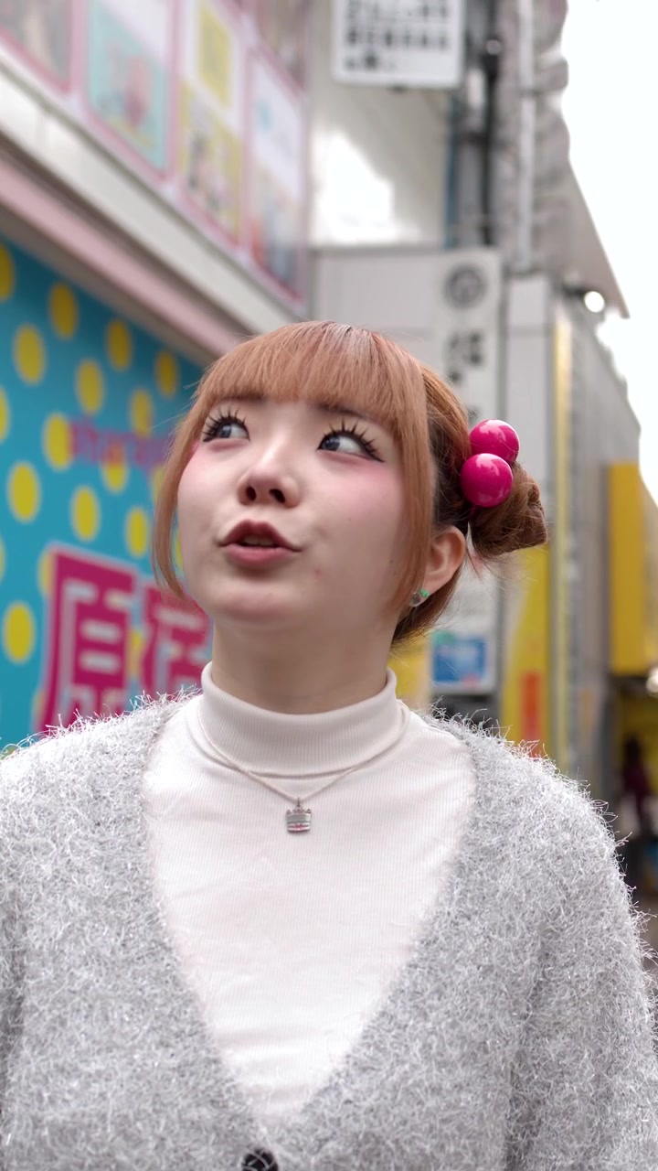 ユニークなヘアアクセサリーをつけたスタイリッシュな若い女性が日中に都会の商店街を散策する