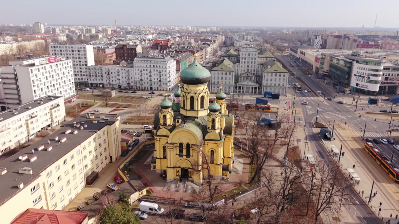 Vista Aérea da Igreja Ortodoxa de Varsóvia com Cúpulas Verdes, Perspectiva de Piloto de Drone Sobre Blocos Residenciais Tranquilos, Linha de Elétrico Passando, Céu Limpo, Luz Quente de Final de Inverno, Marco Urbano Histórico