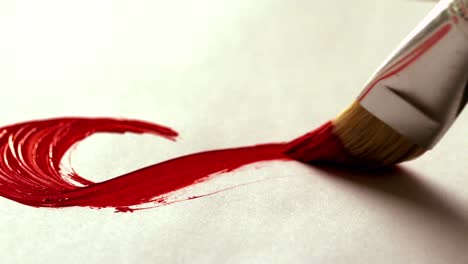 painter painting with red paint and paintbrush