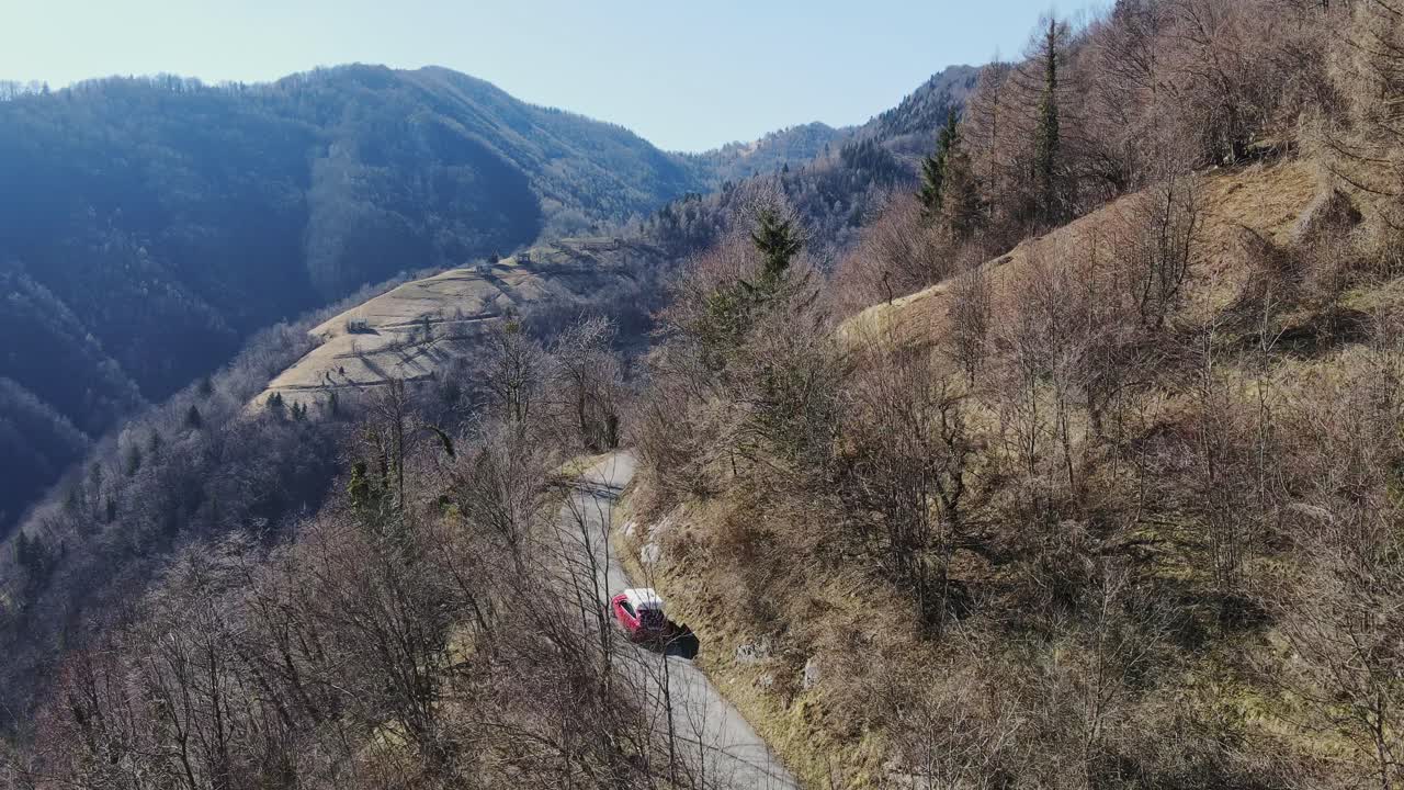 Red Car Driving on a Winding Mountain Road