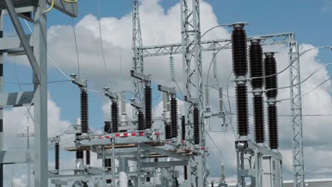 muchos aislantes eléctricos de alto voltaje en la subestación de energía contra un fondo de cielo azul