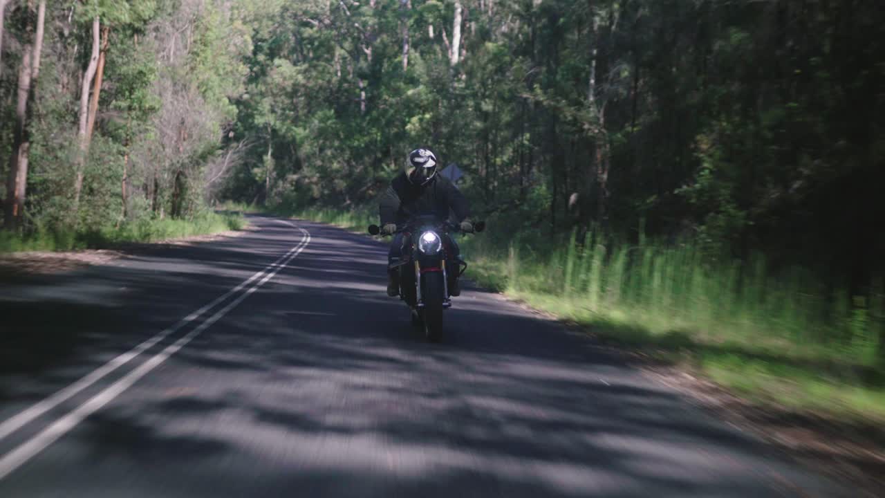 Motorcyclist Riding Through a Forest Road