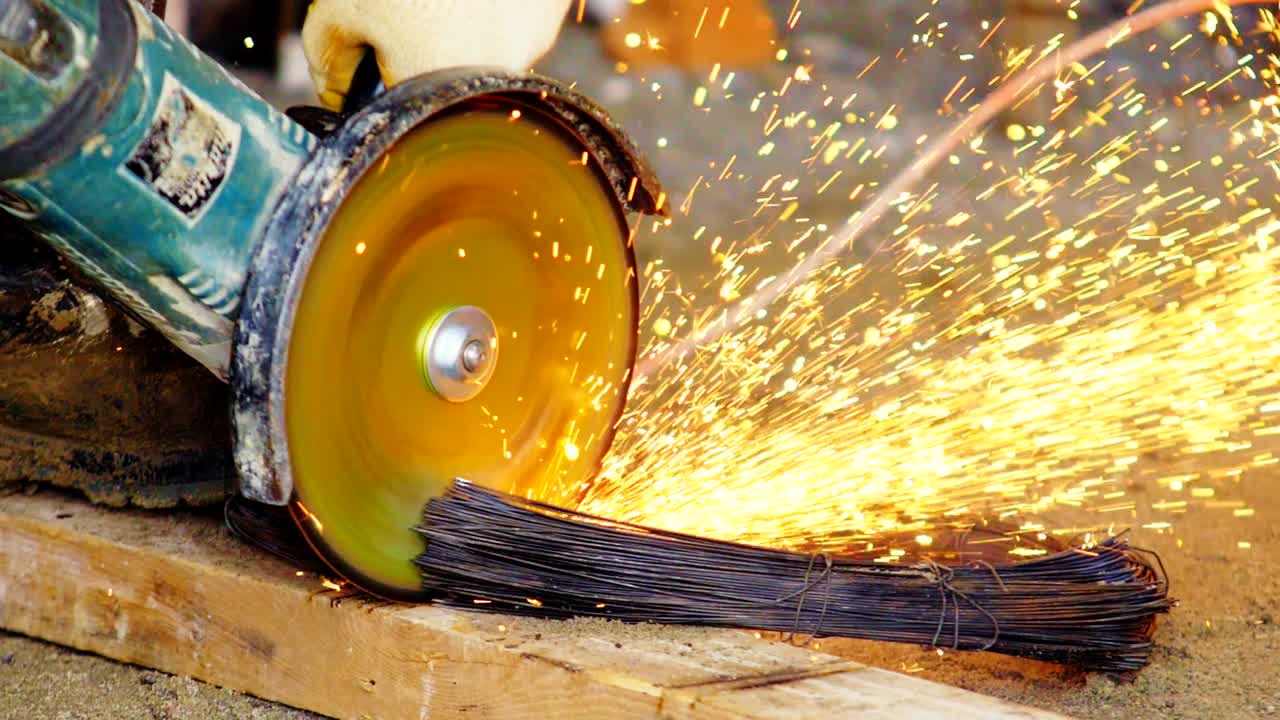 рабочий режет провода мощной круговой пилой на рабочем столе
