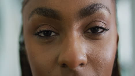 gelukkige afro-amerikaanse vrouw die naar de camera glimlacht.