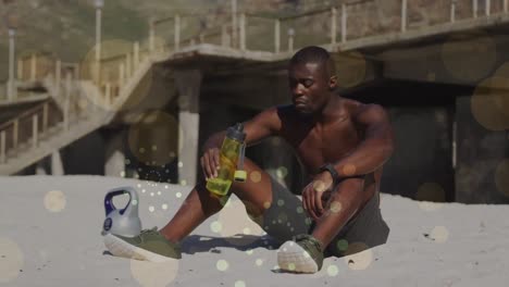 Animation-of-spots-over-african-american-man-drinking-water-at-beach