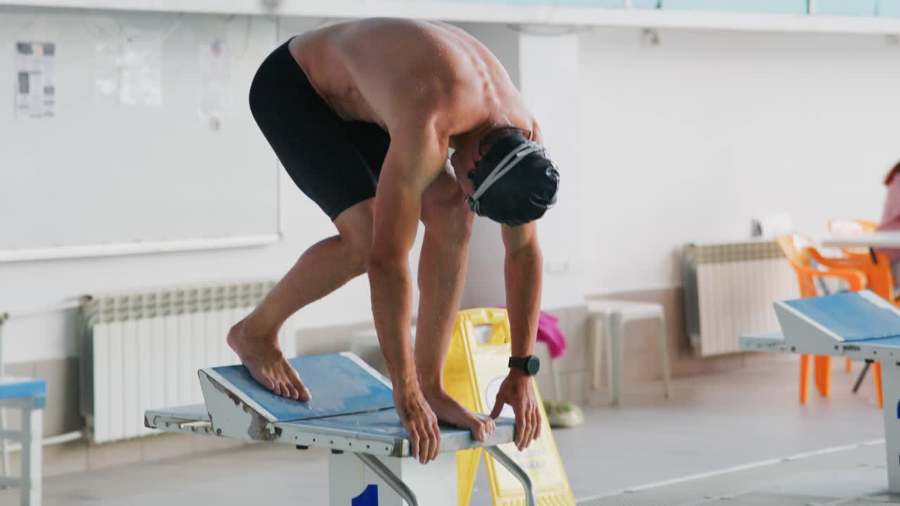 Focused Swimmer Preparing for Dive: Capturing the Intensity and Determination Before the Perfect Start in Competitive Swimming Environment