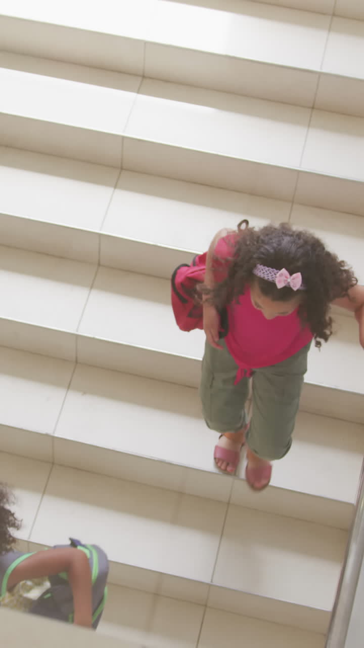 Video di ragazze di etnie diverse riprese dall'alto che scendono le scale a scuola.
