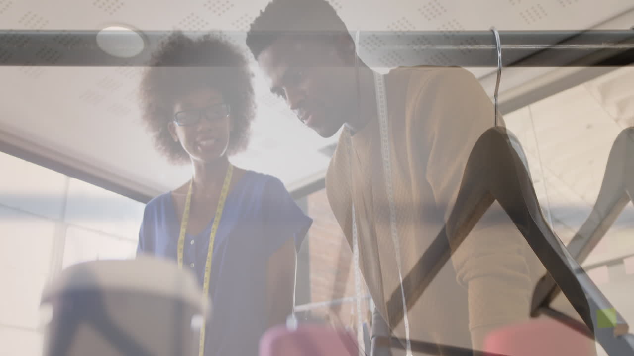 Composite of male and female clothes designers in studio, and clothes hangers on clothes rail