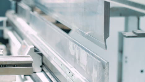 plant worker taking finished product from machine for bending metal