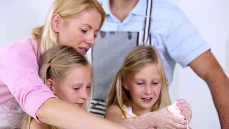 twin sisters making pastry with their parents