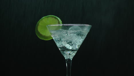 rotating martini glass sprayed with a water can creating a cool rain effect