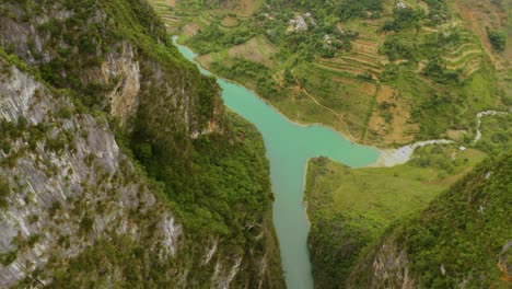 revelación lenta hacia abajo de la preciosa agua verde turquesa cortando entre dos montañas escarpadas
