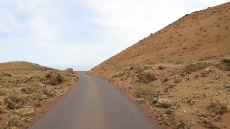 Timanfaya,-Imágenes-Desde-La-Carretera,-Parque-Natural-Volcánico-De-Lanzarote-Conduciendo-Por-La-Carretera-Desde-El-Punto-De-Vista-Frontal-Del-Coche