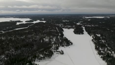 Ice-roads-scattered-throughout-the-frozen-lake-hidden-among-the-boreal-forest-in-northern-Canada