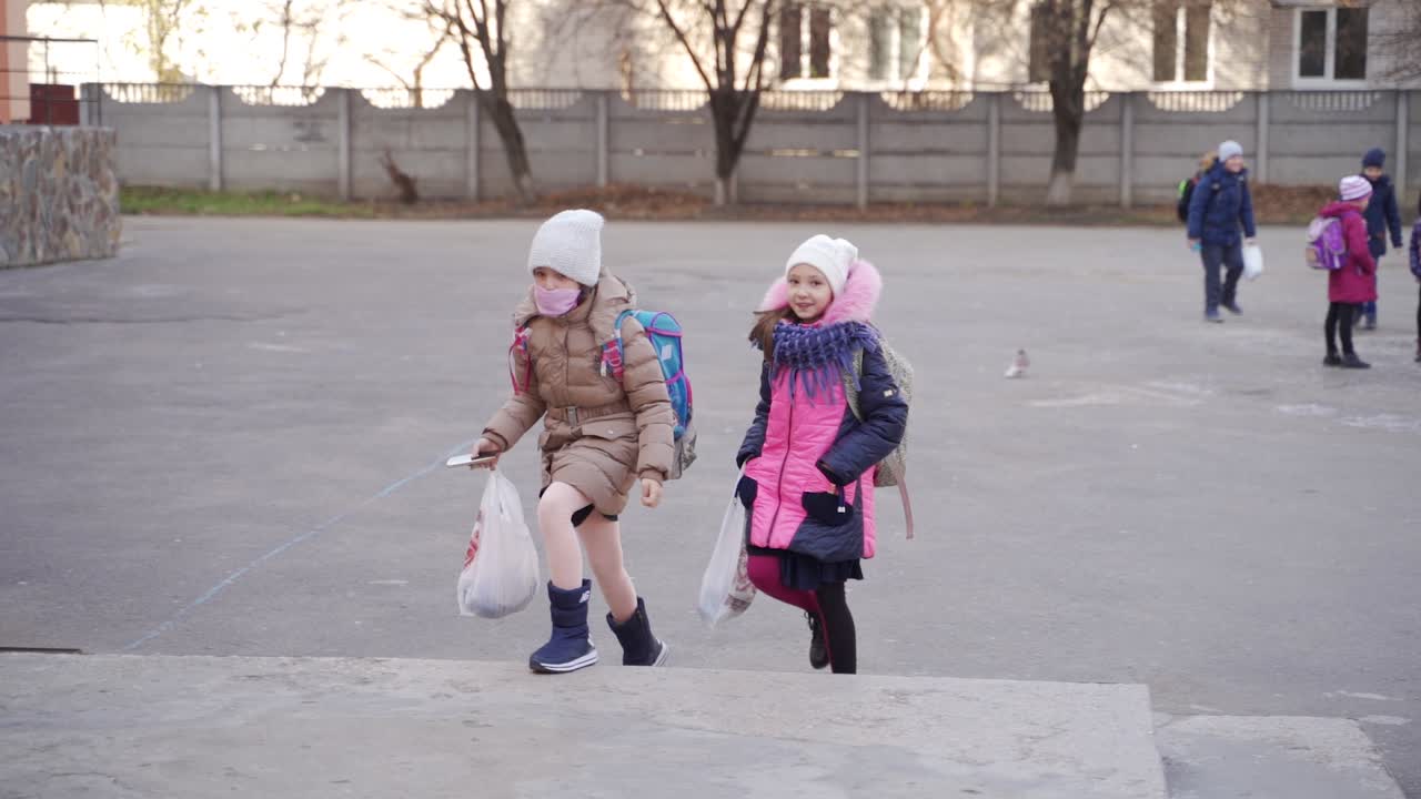 Two girls walking to school in winter