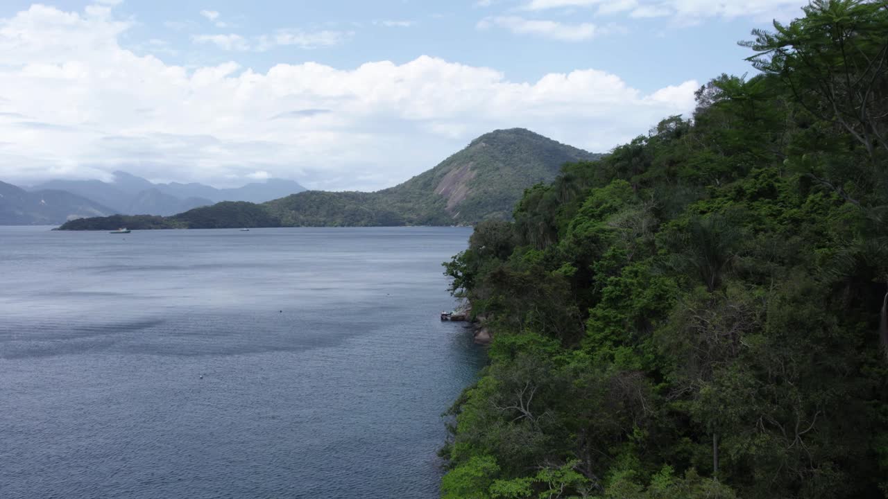 vista aérea volando paralela al mar y la selva costera, en la soleada costa verde, brasil