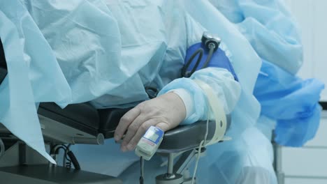 old patient with pulse oximeter on finger for monitoring during surgery in hospital