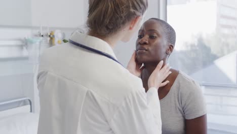 paciente femenina diversa y el médico chequeando su cuello con las manos en el hospital, en cámara lenta