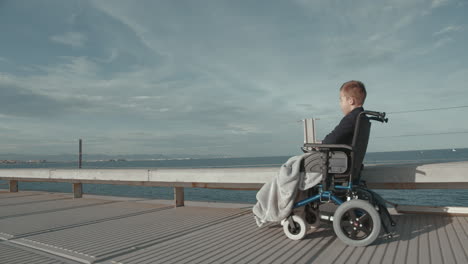 disabled boy in electric wheelchair outside