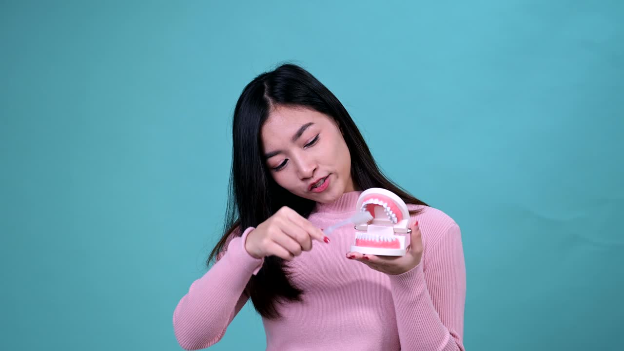 푸른 스크린 배경에 정형 치과 장치를 착용 한 미소 짓는 아시아 여성. 치과 관리와 건강한 치아.