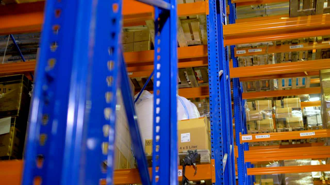 La telecamera si muove tra scaffali, pallet in magazzino. 4K